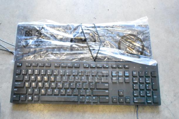 Lot of various items including a black computer keyboard wrapped in plastic. Condition appears used.