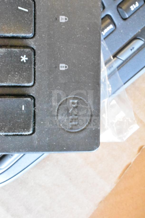 Lot of various items featuring a Dell keyboard with visible logo. Condition shows signs of use. Includes computer mouse.