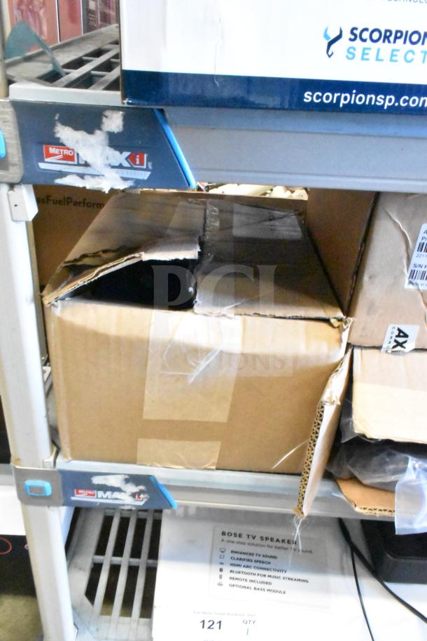 Box on a shelf, partially opened, likely containing Axis T8311 Joystick and Sensormatic Cable. Condition unclear, auction item 121.