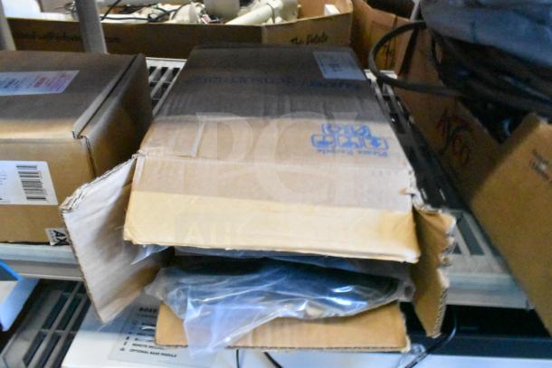 Damaged cardboard box containing Axis T8311 joystick and Sensormatic cable, partially visible, on metal shelf.