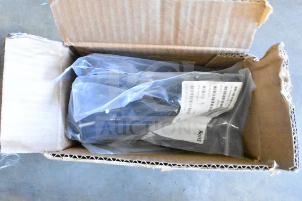 Open box with Axis T8311 joystick and Sensormatic cable in plastic bags. Labels visible, indicating new condition.