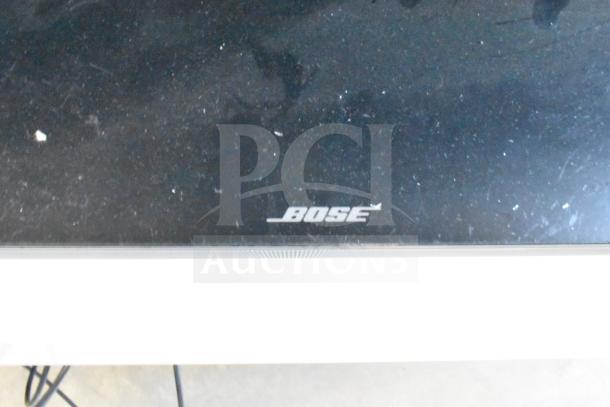 Bose sound bar, black with visible logo, minor scratches, good condition, ideal for enhanced audio experience.