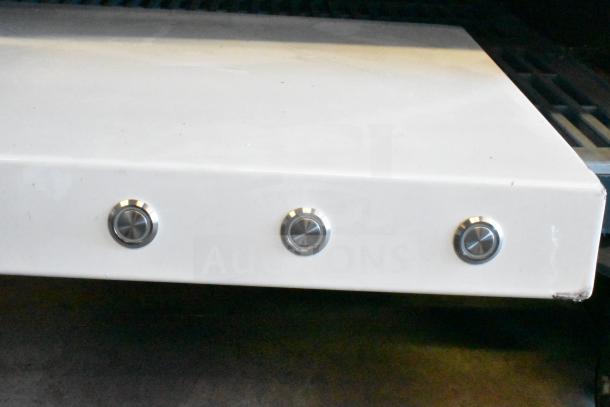 An unidentified white metal panel with four silver control knobs. The item shows signs of wear and surface scratches.