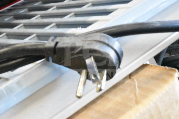 Black power cord plug for Vizio M Series 5.1 Home Theater Sound Bar System Display, attached to metallic backing.