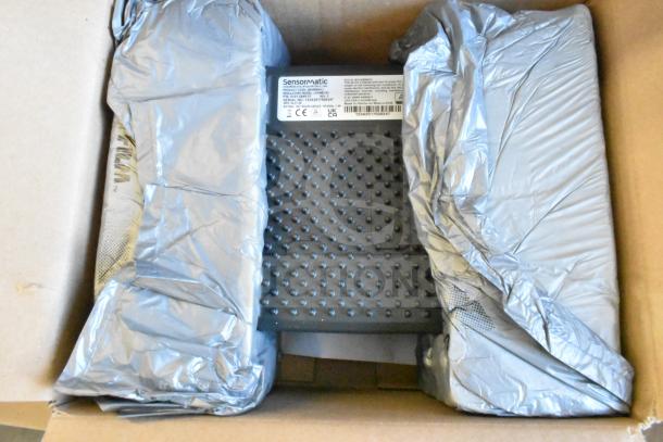 Box containing Sensormatic ZBAMB9012 Label Deactivator Pad and various computer keyboards, wrapped in protective packaging.