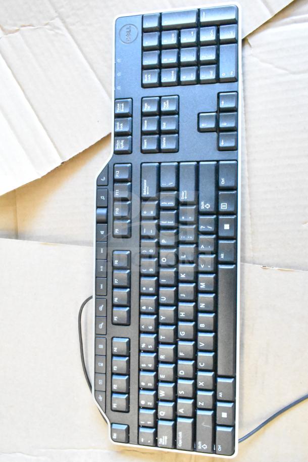 Dell wired keyboard in good condition, black color with numeric keypad, visible Dell logo on top left.