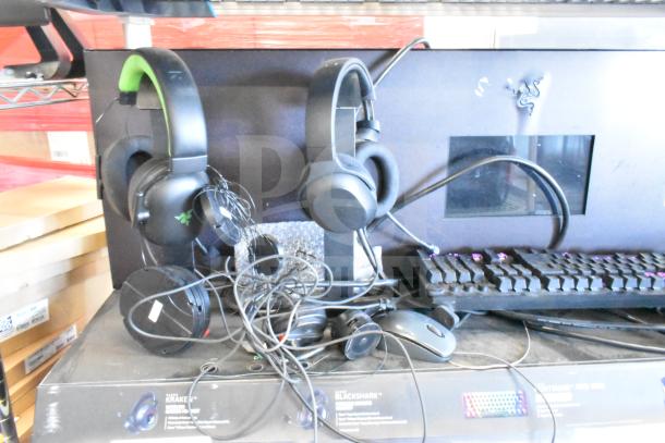 Gaming store display with Razer headphones, keyboard, and computer mouse. Includes visible labels and wiring. Good condition.