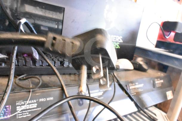 Gaming store display featuring a Razer Huntsman Pro Mini Keyboard, headphones, and computer mouse. Labels visible.