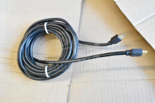 Coiled black HDMI cable with connectors, labeled "AWM 20276 80C 30V VW-1," on a cardboard surface.