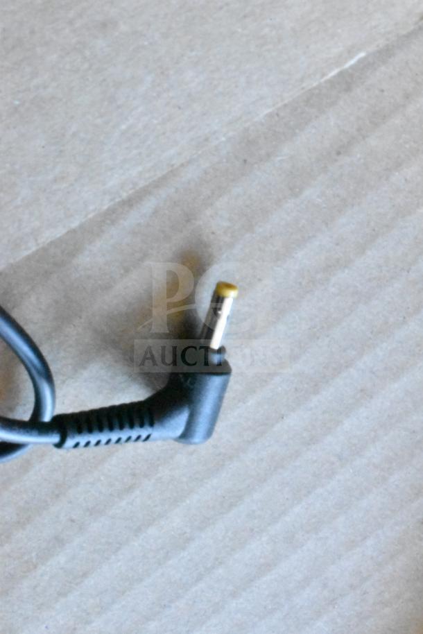 Mixed item lot including an HDMI splitter and various cables on a cardboard surface.