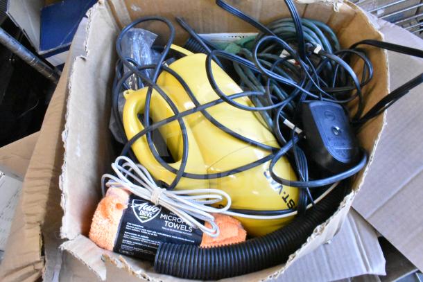 Lot of various items including a yellow Dust Vac, orange microfiber towel with "Auto Drive" label, and cords in a box.