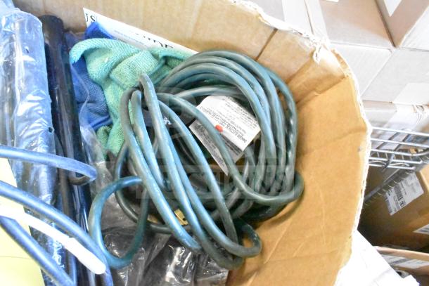 Box with various items, including a green microfiber towel, dust vac, and coiled cord. Tag with electrical info visible.