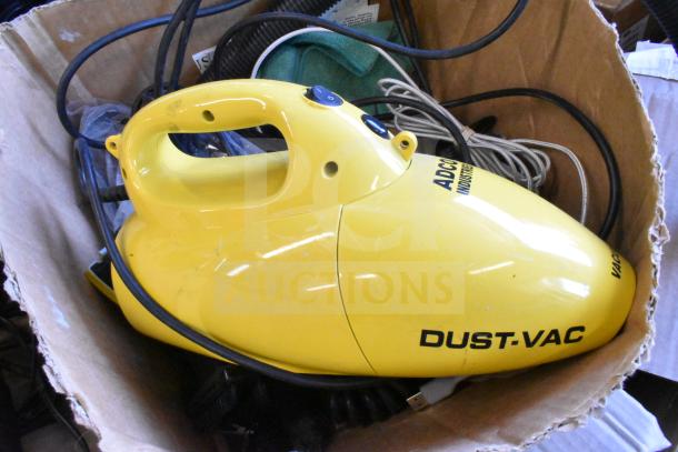 Lot includes yellow Dust Vac, microfiber towel, various cords in used condition, with visible labels "ADC" and "Dust-Vac."