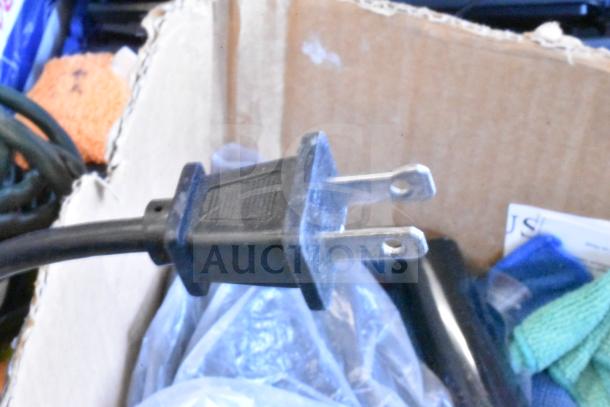 Lot of various items including a microfiber towel, dust vac, and power cord, all in fair condition inside a cardboard box.