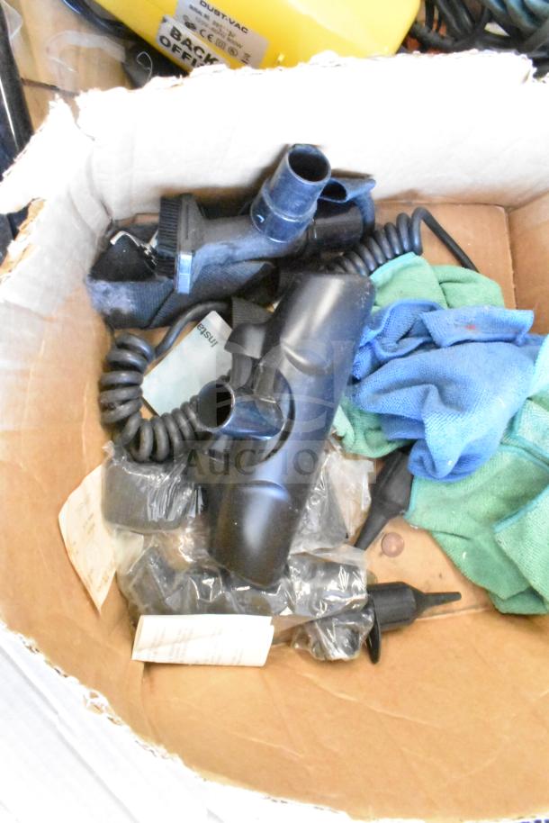 Box containing a collection including a microfiber towel, Dust Vac attachment, and various cords. Items appear used.
