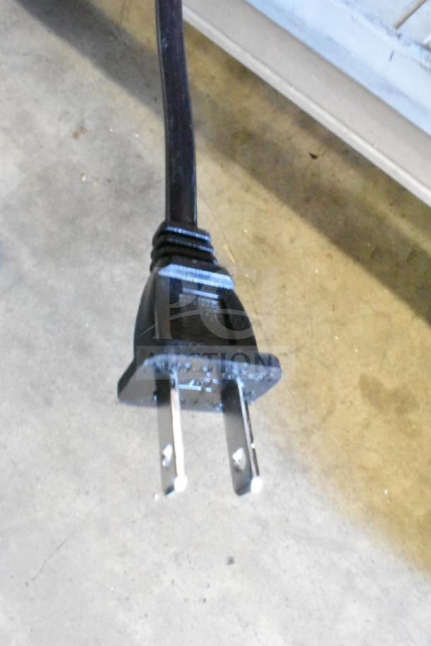 Power plug attached to LG store display sound bar and speaker, standard two-prong design, good condition.