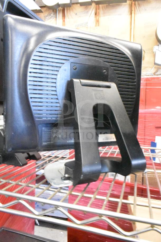 Four monitors including Costar, HP Compaq LE1711, Elo TouchSystems, and Acer S240HL, on wire shelving.