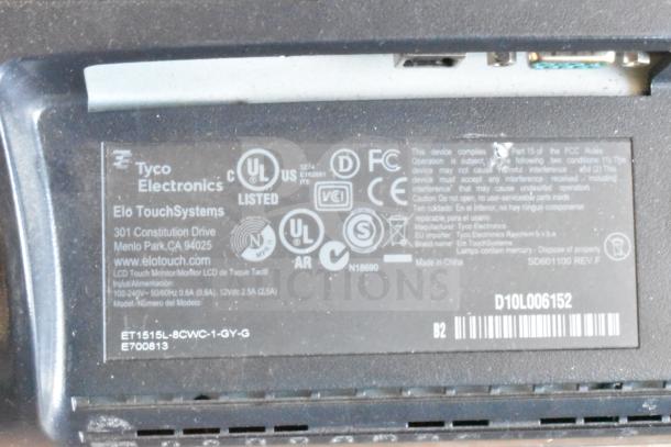 Label on Elo TouchSystems monitor shows compliance logos, model ET1515L-8CWC-1-GY-G, with Tyco Electronics branding.