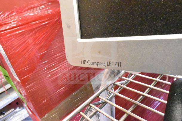 4 monitors: Costar, HP Compaq LE1711, Elo TouchSystems, Acer S240HL. Visible text: "HP Compaq LE1711." On metal shelf.