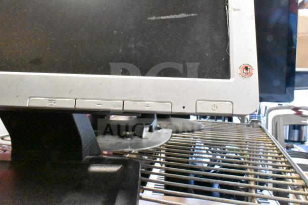 Four monitors, including Costar, HP Compaq LE1711, Elo TouchSystems, Acer S240HL, shown on a metal rack. Multiple buttons visible.