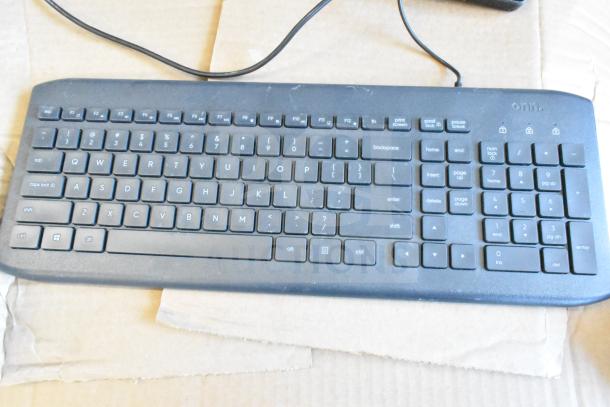 Black wired computer keyboard with full QWERTY layout and numeric keypad. Moderate wear. Sold in a lot of 40.