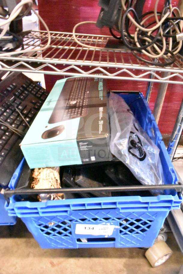Blue crate containing computer keyboards and mouse, Logitech box visible, mixed condition. Auction lot of 40 items.