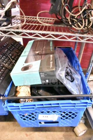 Blue crate containing computer keyboards and mouse, Logitech box visible, mixed condition. Auction lot of 40 items.