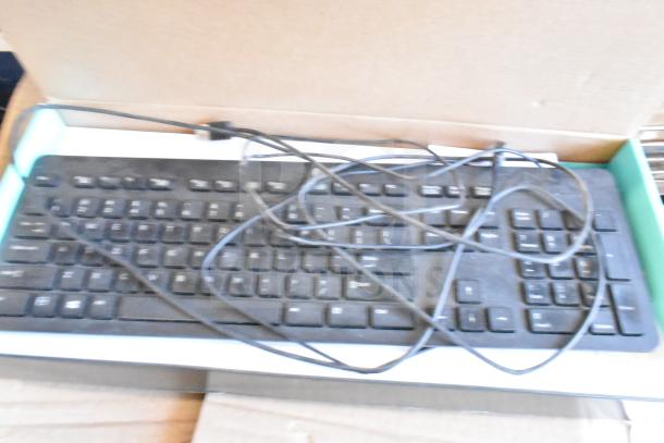 Box containing computer keyboards with tangled cables, part of a lot of 40 items including mice. Condition appears used.