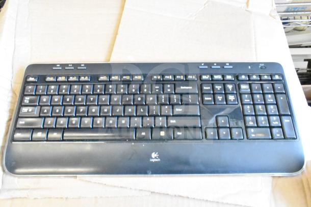 Logitech keyboard on cardboard; part of 40 electronic items lot. Functional keys visible.