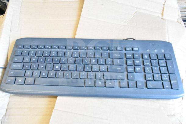Black computer keyboard by Onn on cardboard, features full layout and numeric keypad. Auction of 40 items, mixed condition.