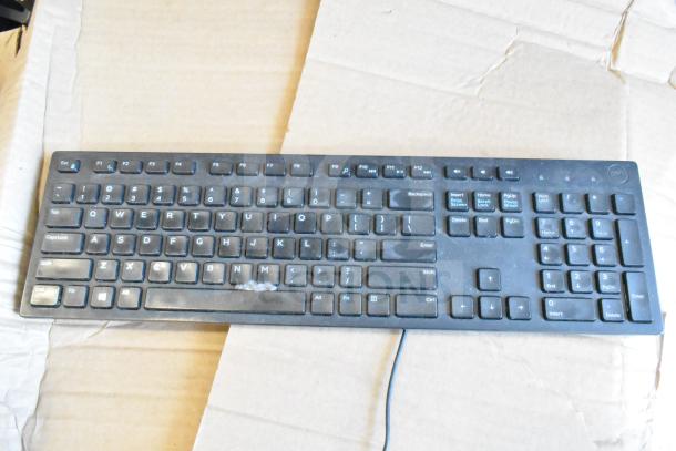 Black wired keyboard on cardboard, showing full QWERTY layout. Slight wear visible. Includes 40 similar items in auction.