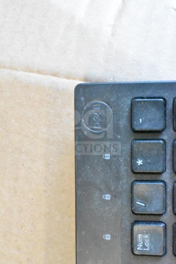 Close-up of a Dell keyboard corner, featuring numeric keys and lock symbols. Lightly dusty, indicating used condition.