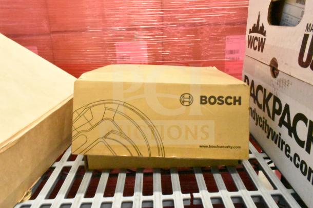 Cardboard box labeled "Bosch" containing a Bosch pendant interface plate, part of a lot with various electronics including a CCTV camera.