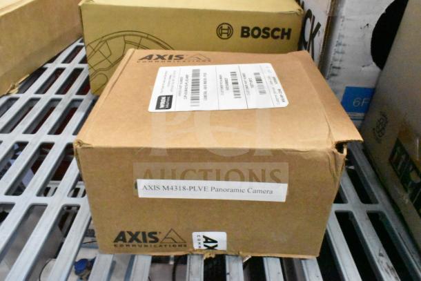 Cardboard box labeled "AXIS M4318-PLVE Panoramic Camera" and "Wren Solutions," on a metal shelf.