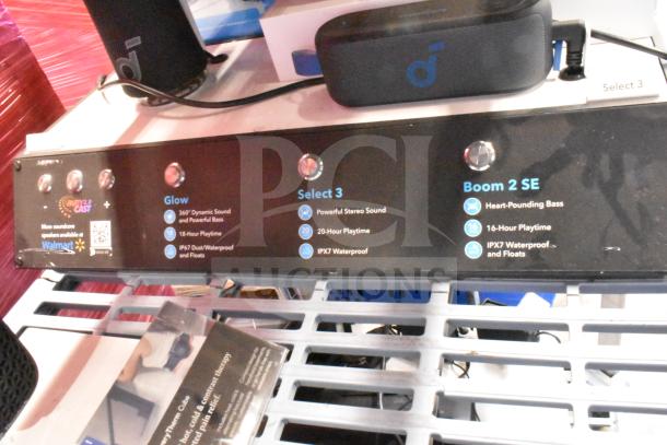 Soundcore store display featuring three speakers: Glow, Select 3, Boom 2 SE, with details on sound, playtime, and waterproofing.