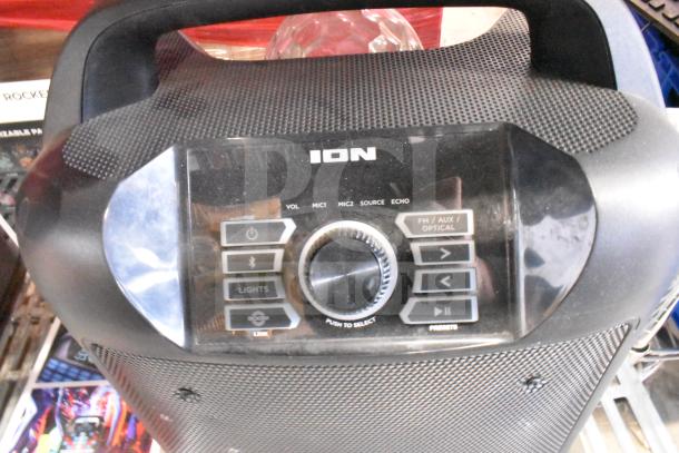 Ion store display speaker, black with control panel, featuring buttons for volume, mic, source, and lights.
