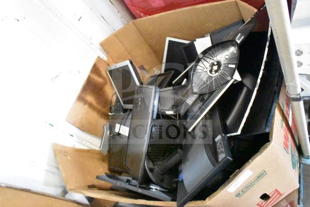 Cardboard box filled with assorted monitors including HP, Samsung, and Dell. Mixed conditions, sold as a lot of 25.