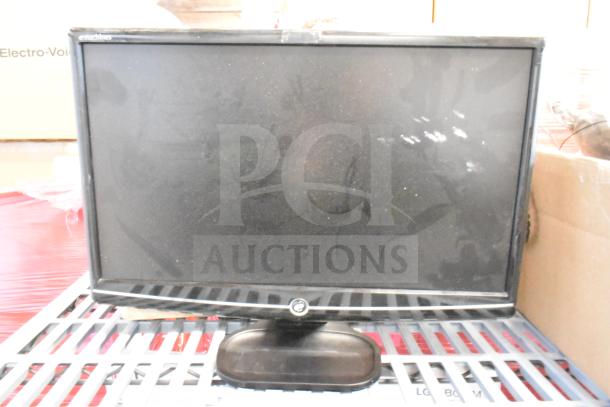 Alt text: eMachines monitor, rectangular screen with visible dust, black frame and stand, resting on a metal surface.