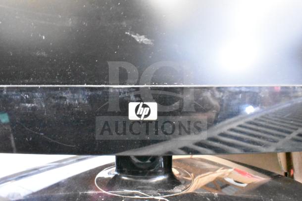 HP monitor close-up with visible logo, part of a lot of 25 mixed-brand monitors, including Samsung and Dell.