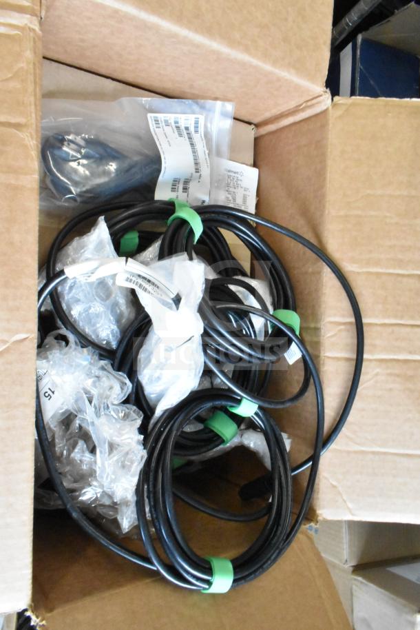 Box containing Sensormatic ZBAMB9010-IPS label deactivator controller, various cables, and plastic-wrapped items.