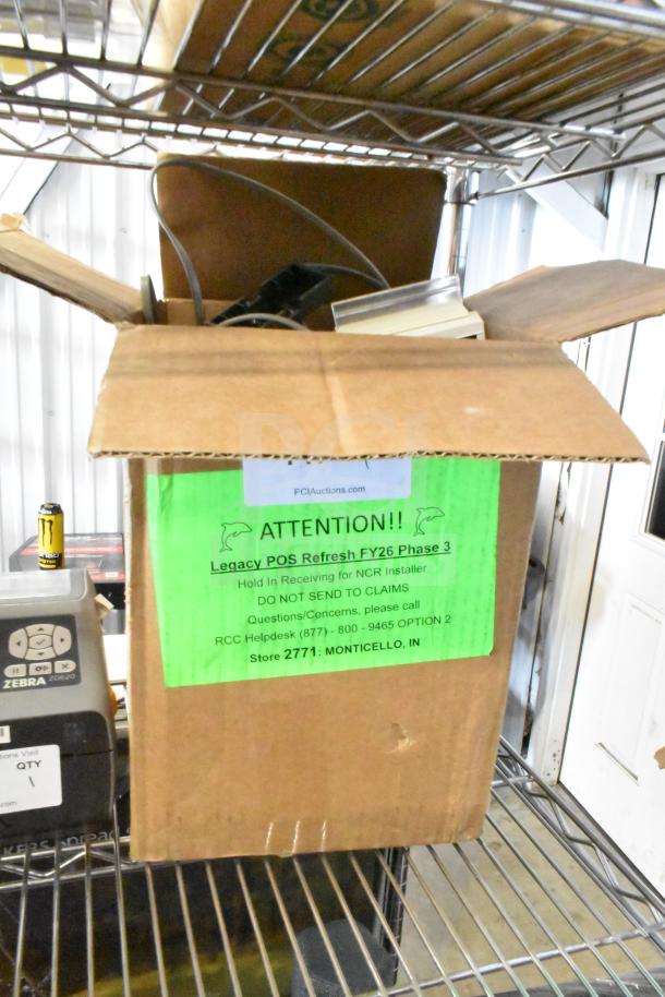 Lot of various items in an open box including a Toshiba price monitor. Box labeled "Legacy POS Refresh FY26 Phase 3." Condition unclear.