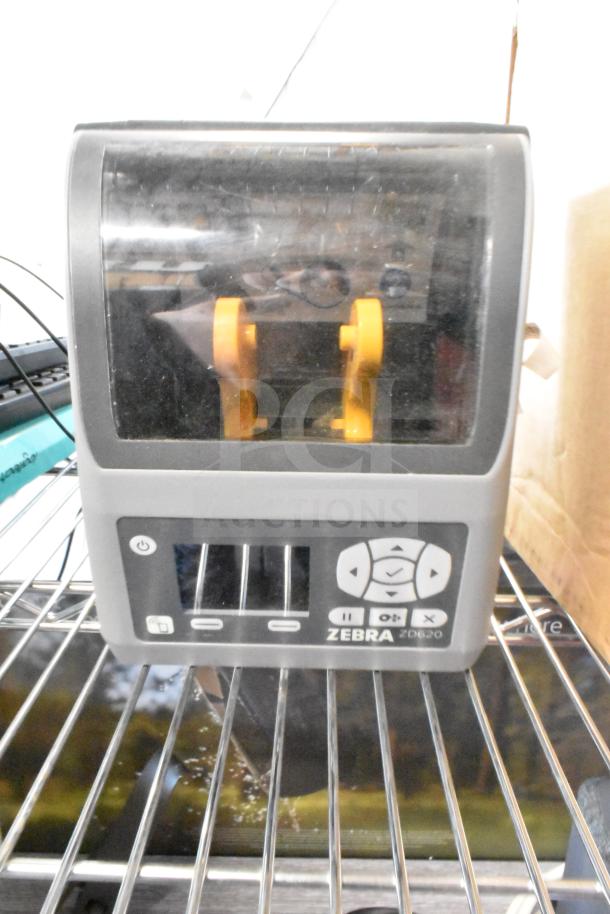 Zebra ZD620 thermal barcode printer, gray, with visible control buttons and brand logo, in used condition.