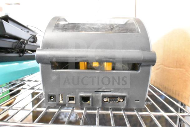 Zebra ZD620 Thermal Barcode Printer, rear view showing ports, black casing, appears in used condition on a metal shelf.