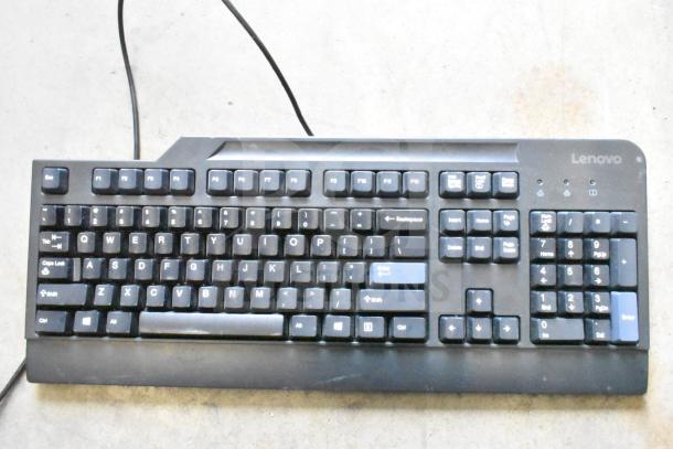 Lenovo computer keyboard with full QWERTY layout, numeric keypad, wired connection, used condition, visible branding.