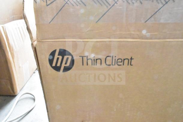HP Thin Client packaging box. Brown cardboard with visible HP logo and text. Box shows signs of wear.