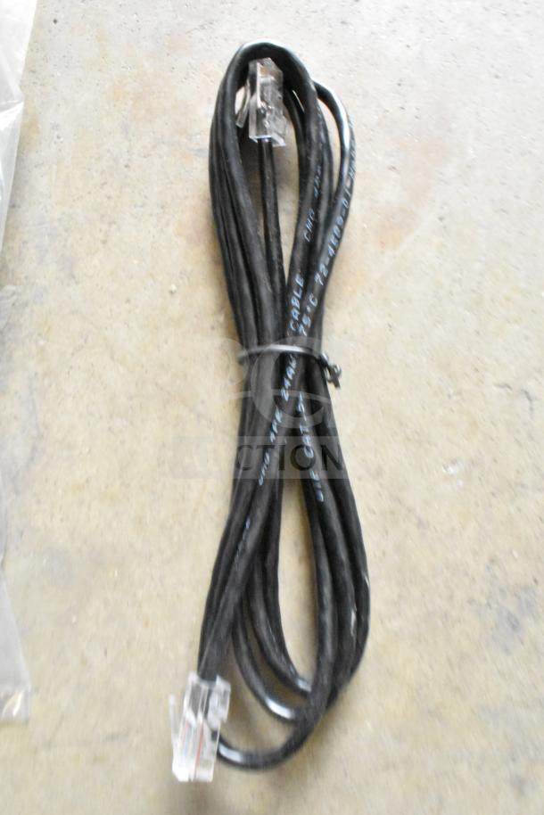 Coiled black cable with connectors, labeled "24 AWG 72-6100-01," indicating its type and specifications.