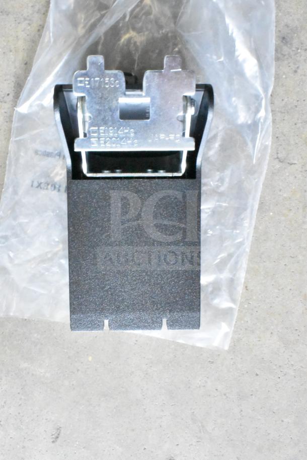 A metal and plastic component on a plastic bag. Markings include codes like EE17153C. Part of a mixed lot, condition unknown.