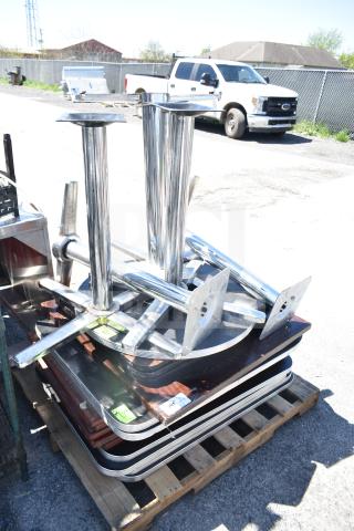 Stacks of assorted tabletops and table bases, metal bases with mounting plates on wooden pallets. Includes 17 pieces.