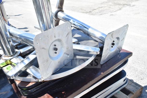 17 mixed items, including shiny metal table bases and stacked black and wooden tabletops, auctioned as bulk.