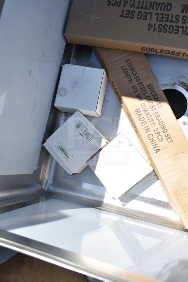 Brand new Regency 600S3242424C L-shaped 3 bay sink with dual drain boards. Scratch and dent condition. No legs included. Boxes and packaging visible in the image.